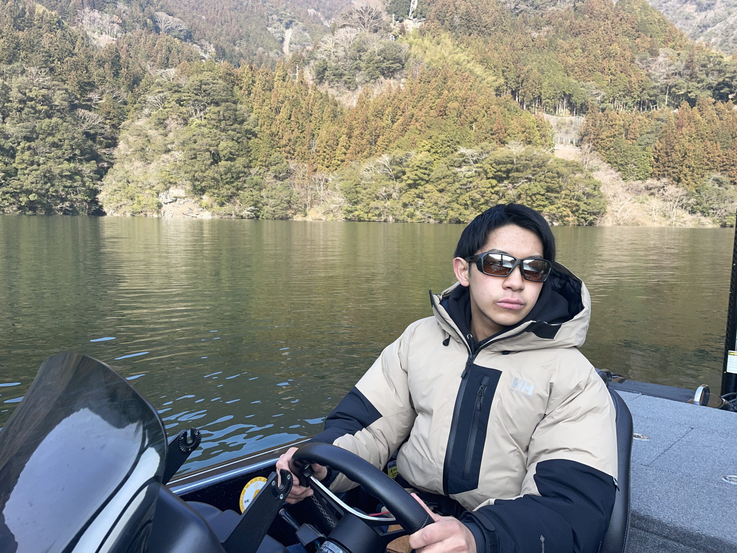 ゼクーの偏光サングラス、ルーフを着用してボート走行している写真